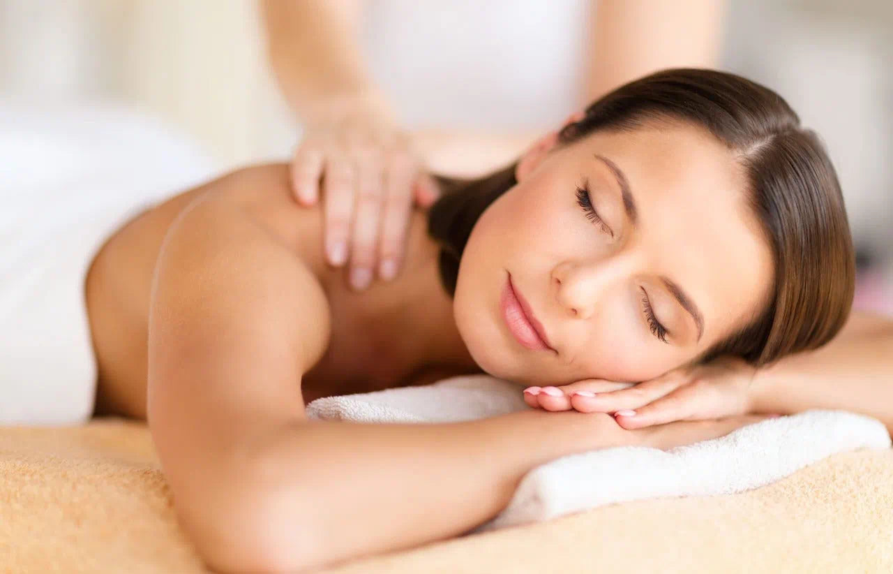 femme au visage détendue se faisant masser
